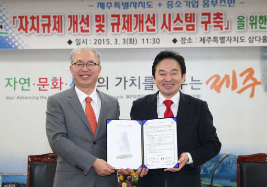 김문겸 중소기업 옴부즈만(사진 왼쪽)과 원희룡 제주특별자치도지사(오른쪽)이 3일 제주 삼다홀에서 업무협약을 체결 후 협약서를 들어보이고 있다.   중소기업 옴부즈만 제공